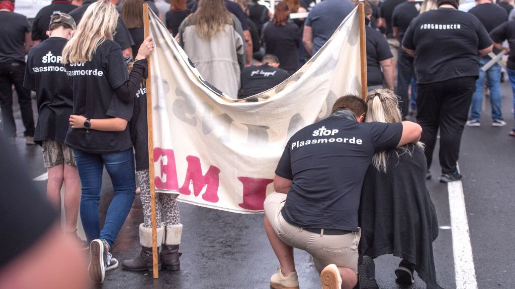 Protesters against farm murder kneel in street